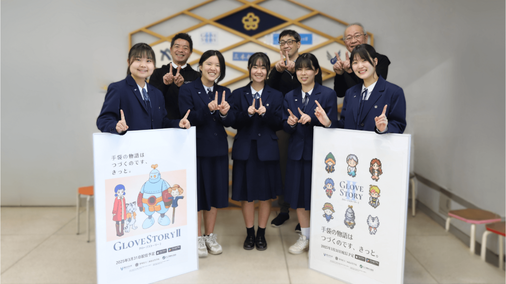 高校生と開発関係者が「Glove Story2」のポスターを手に並び、指で「1」のポーズをしながら笑顔で記念撮影をしている。